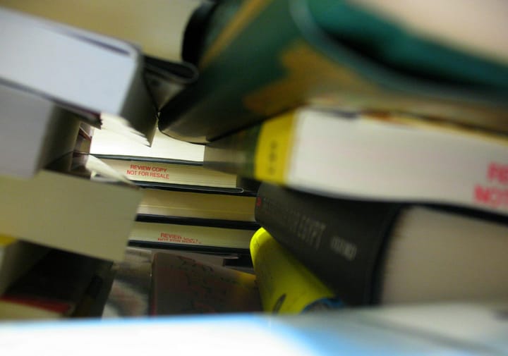 Stacks of books, some of which have "Review copy, not for resale" printed on their binding.
